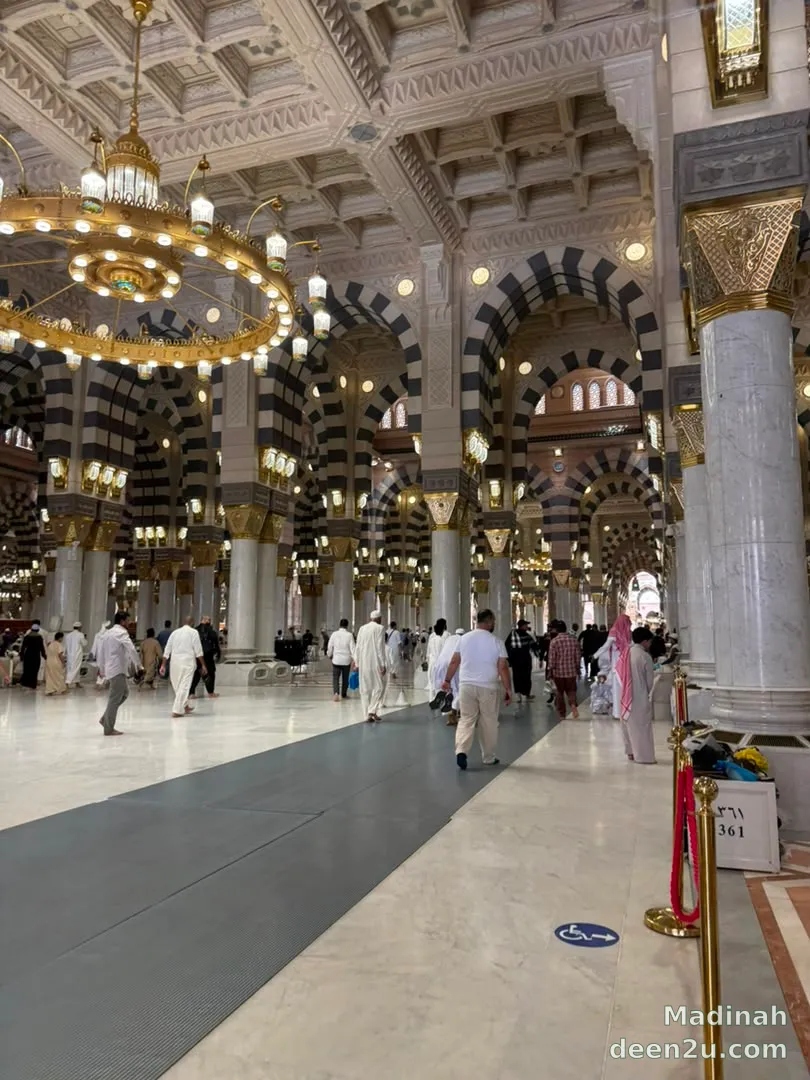 The interior of Masjid an-Nabawi in Madinah — its columns, arches and hanging chandeliers.